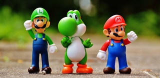 foto de brinquedos do mário, na esquerda o luigi, no meio o yoshi e na direita o mário